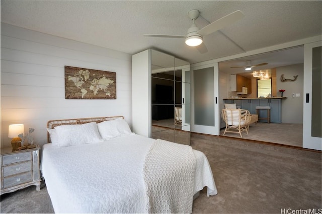 bedroom with dark colored carpet, ceiling fan, a textured ceiling, and a closet