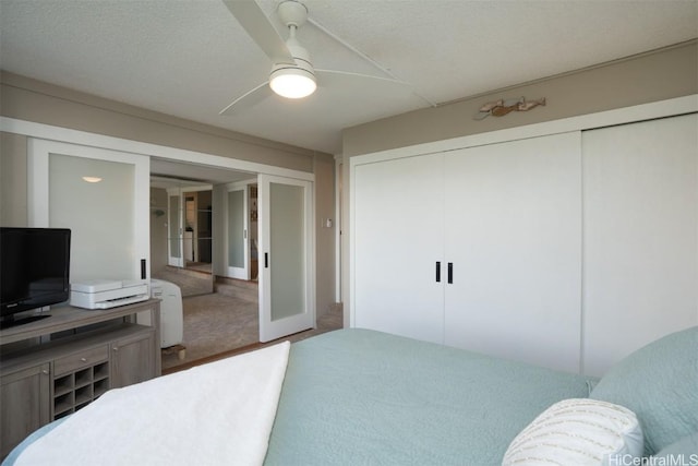 bedroom with ceiling fan, french doors, and a textured ceiling