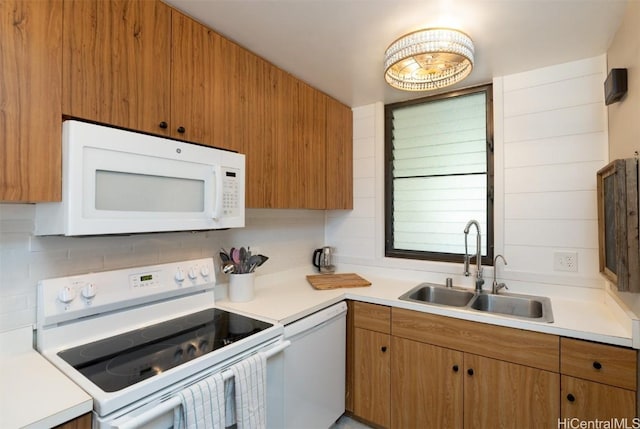 kitchen featuring backsplash, sink, and white appliances