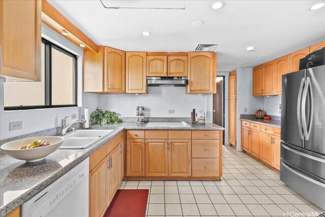 kitchen with sink, electric cooktop, light tile patterned floors, white dishwasher, and stainless steel refrigerator