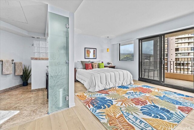 bedroom with wood-type flooring and access to outside