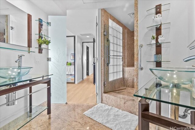 bathroom with a tile shower and sink