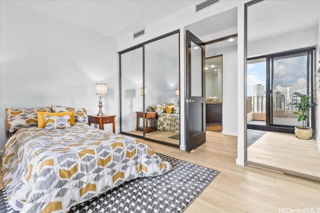 bedroom featuring light hardwood / wood-style floors, a closet, and access to exterior