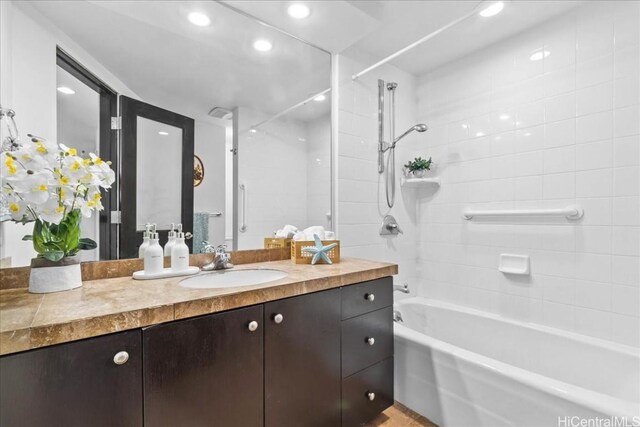 bathroom with tiled shower / bath combo and vanity