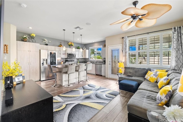 living room featuring light hardwood / wood-style flooring and ceiling fan