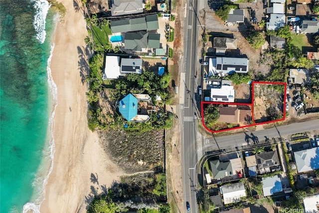 drone / aerial view featuring a beach view and a water view