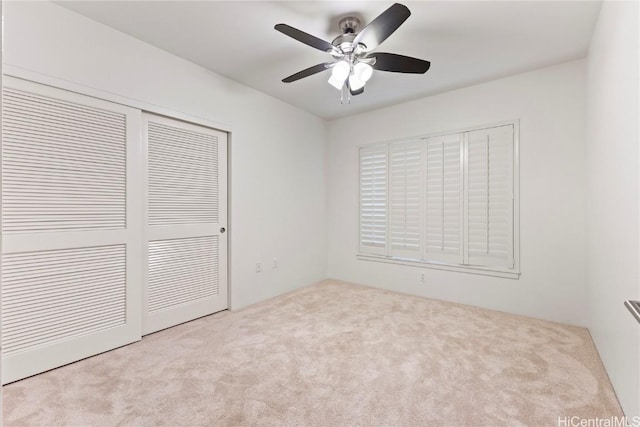 unfurnished bedroom featuring carpet floors, a closet, and ceiling fan