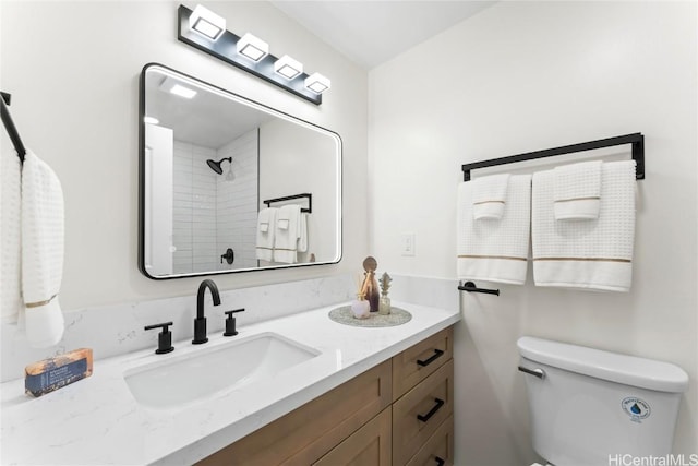 bathroom with toilet, vanity, and walk in shower