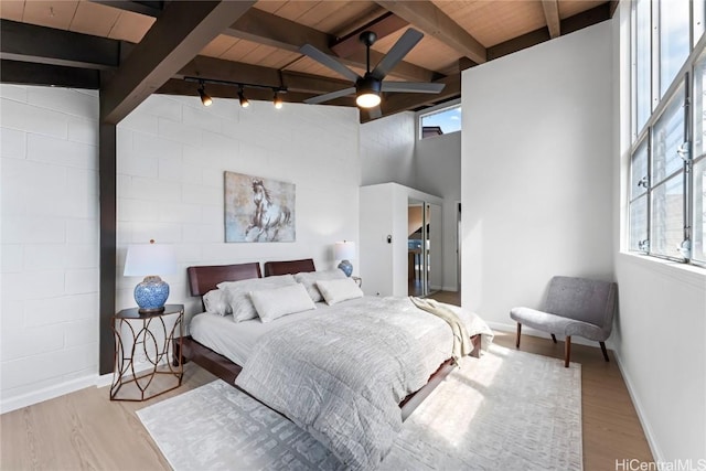 bedroom with ceiling fan, multiple windows, track lighting, and wood ceiling