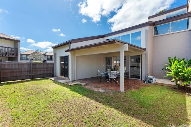 back of house featuring a lawn and a patio