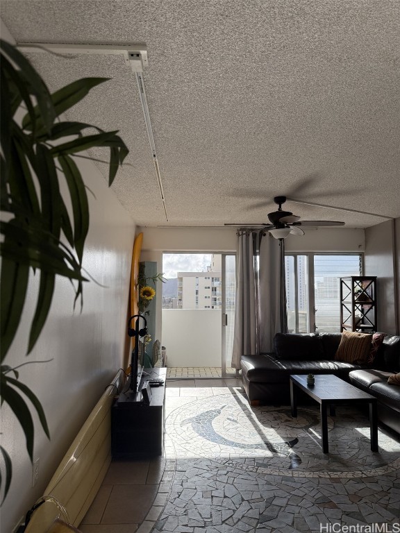 living room with a textured ceiling and ceiling fan