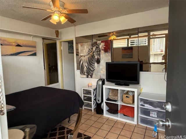 bedroom with light tile patterned floors, a textured ceiling, and ceiling fan