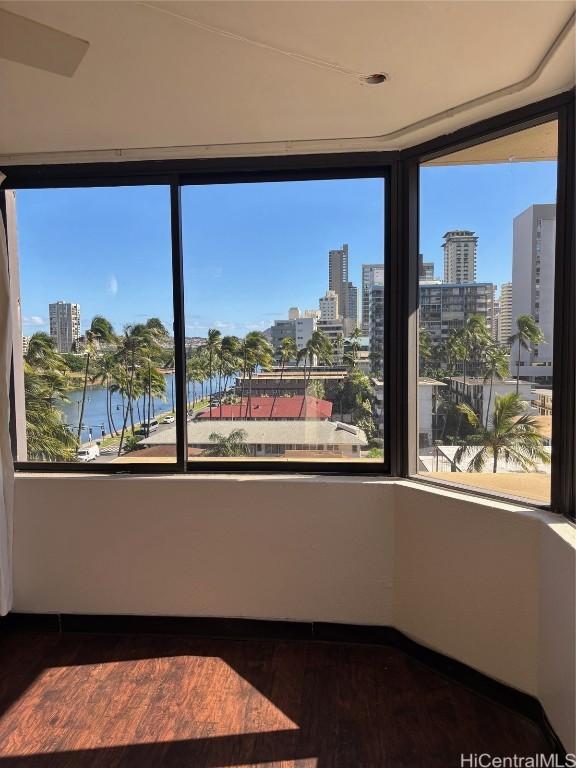 unfurnished room featuring a water view and dark wood-type flooring