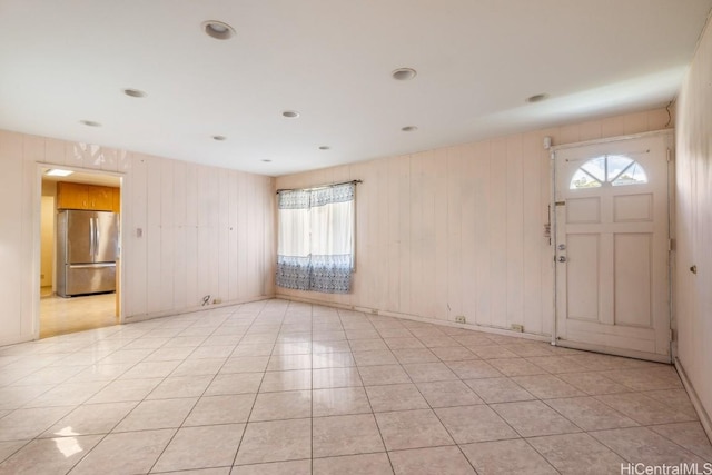 tiled foyer entrance featuring wood walls