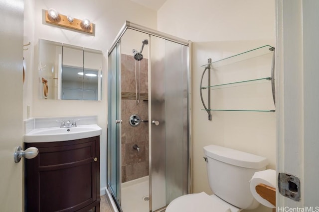 bathroom featuring vanity, an enclosed shower, and toilet