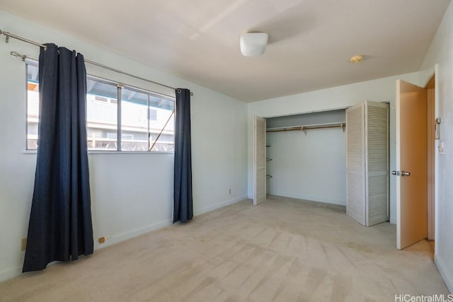 unfurnished bedroom featuring light carpet and a closet