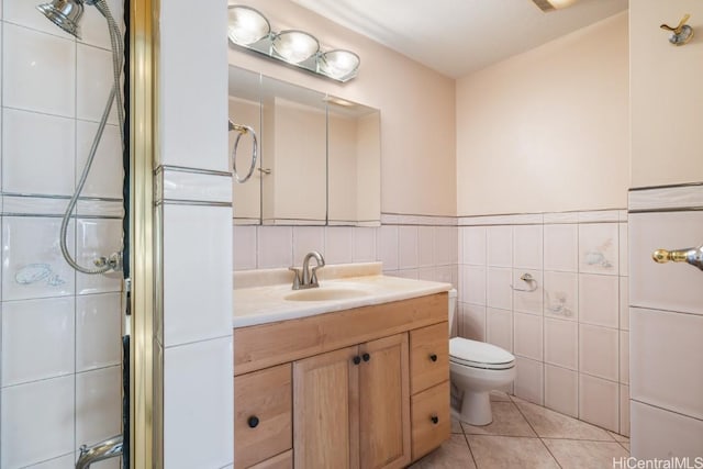 bathroom with vanity, tile patterned floors, toilet, tile walls, and a shower with shower door