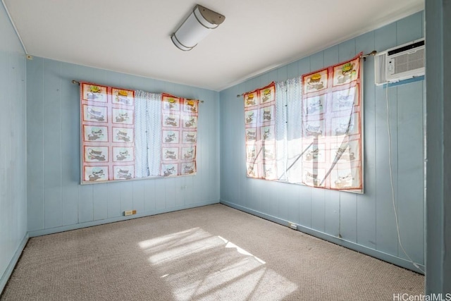 spare room with a wall mounted air conditioner and light carpet