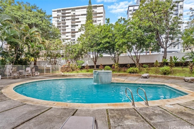 view of swimming pool with pool water feature and a patio