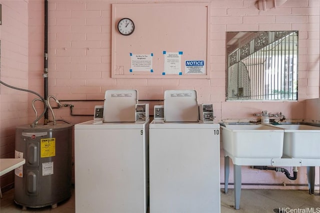 laundry area with water heater, brick wall, and washer / dryer