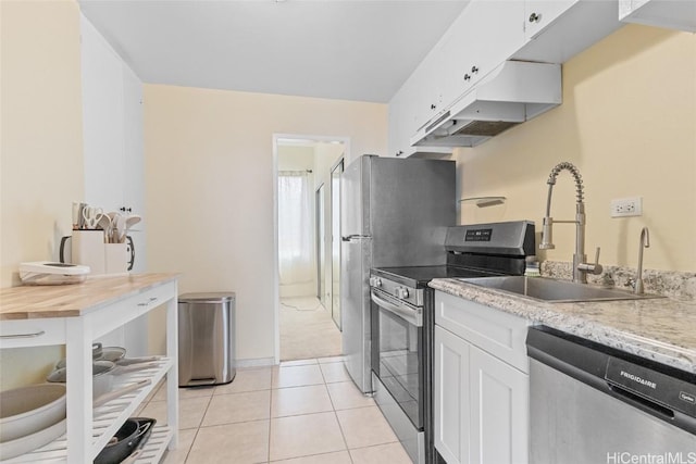 kitchen featuring white cabinets, appliances with stainless steel finishes, sink, and light tile patterned floors