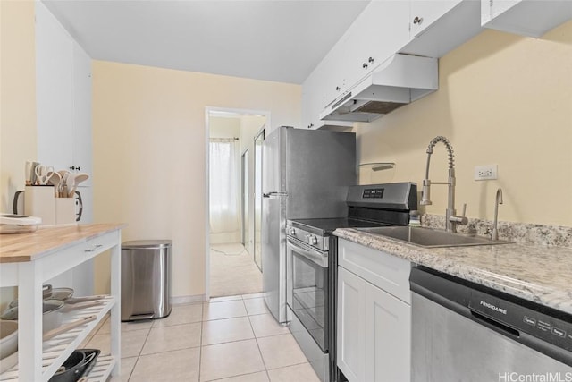 kitchen with sink, white cabinetry, stainless steel appliances, and light tile patterned flooring