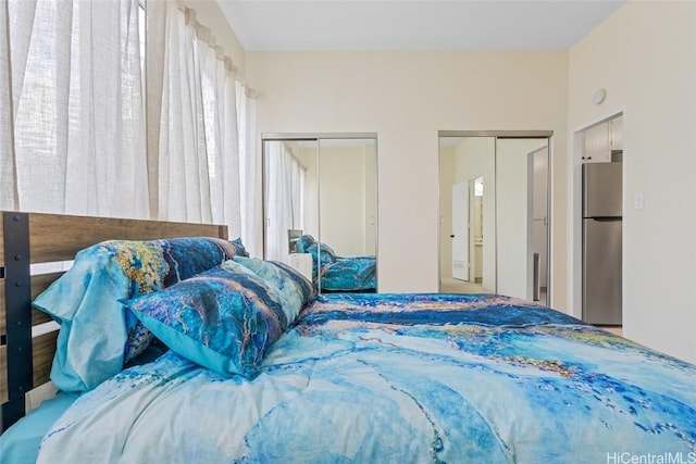 bedroom featuring multiple closets and stainless steel fridge