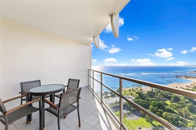 balcony with a water view and a view of the beach