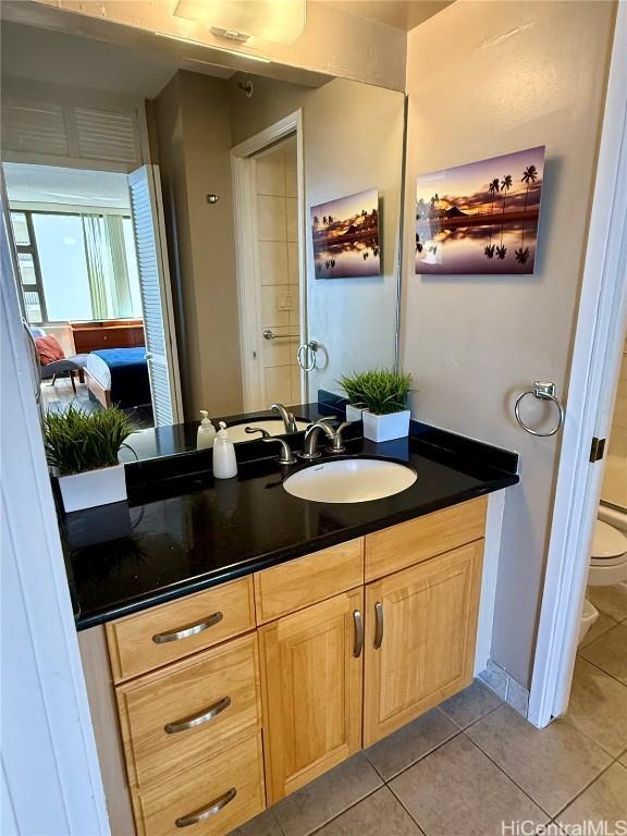 bathroom with toilet, tile patterned floors, and vanity