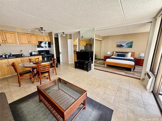 living room with light tile patterned floors, a textured ceiling, a ceiling fan, and an AC wall unit