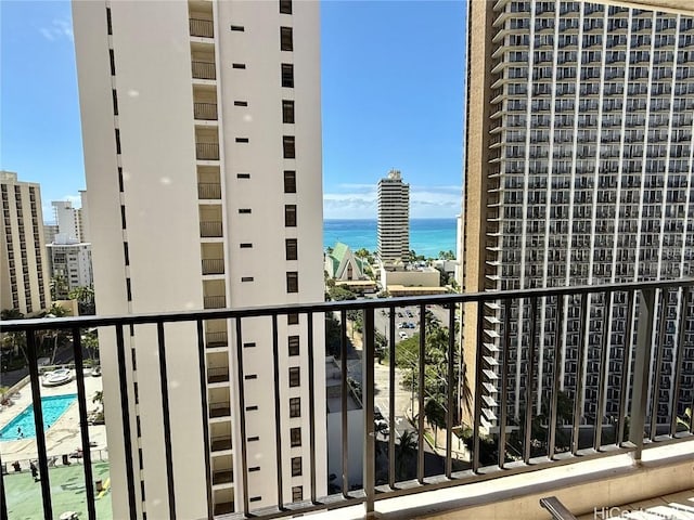 balcony with a water view and a view of city