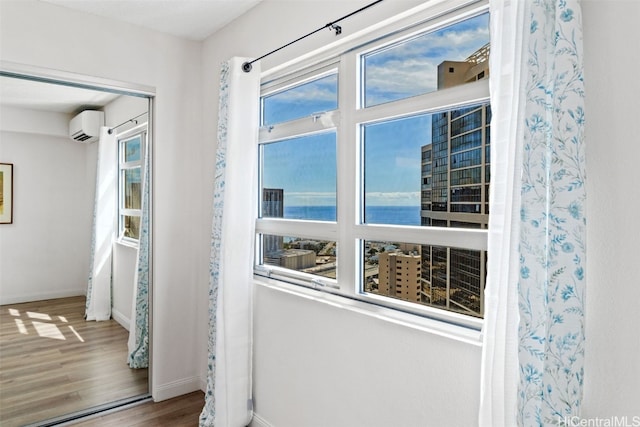 hallway with a wall mounted air conditioner, a water view, and hardwood / wood-style floors