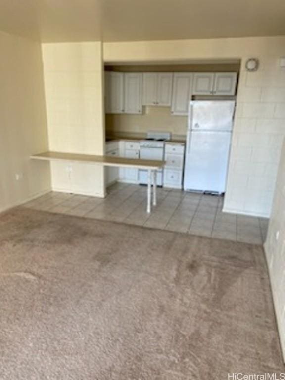 kitchen with light carpet and white fridge