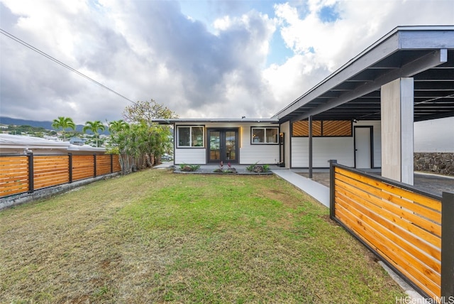 rear view of house featuring a lawn