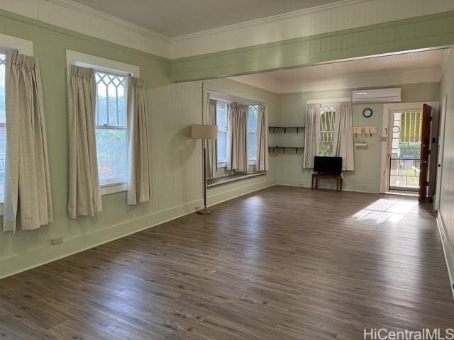 unfurnished living room featuring dark hardwood / wood-style flooring, a wall mounted AC, and crown molding