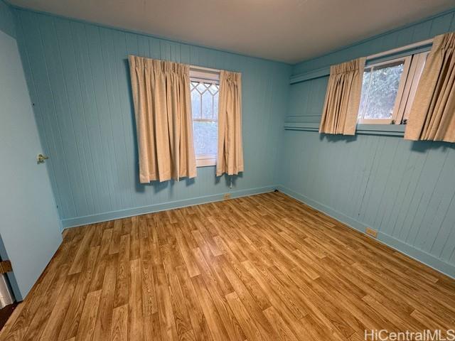 spare room featuring plenty of natural light and hardwood / wood-style flooring