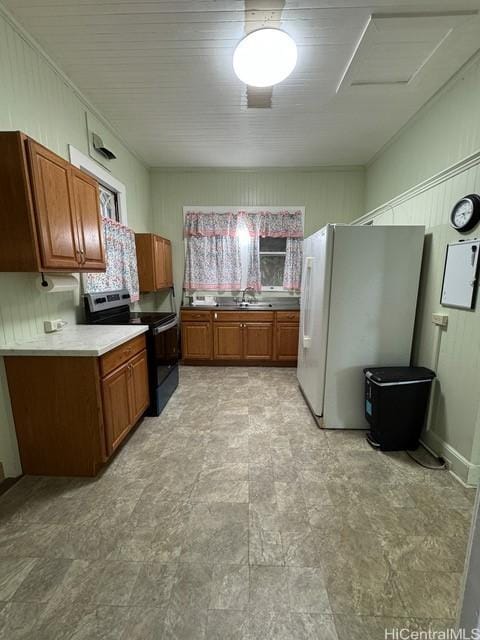 kitchen with electric range, white fridge, and sink