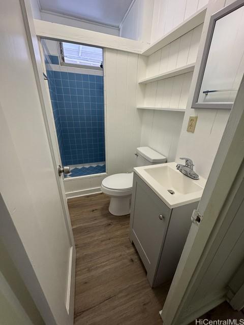 full bathroom with toilet, hardwood / wood-style floors, vanity, and tiled shower / bath