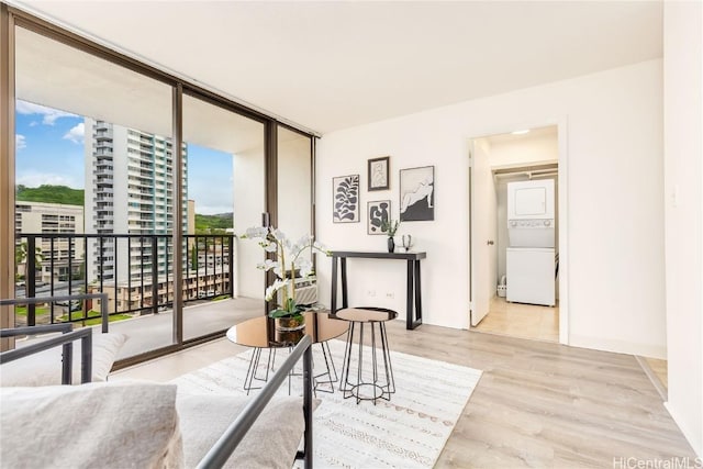 interior space with light hardwood / wood-style floors, expansive windows, and stacked washer and clothes dryer