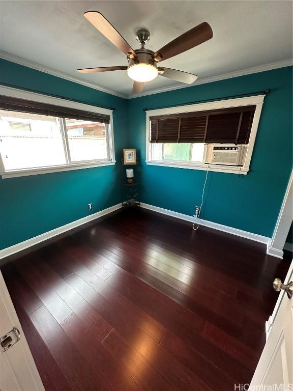 empty room featuring dark wood-type flooring, ceiling fan, ornamental molding, and a wealth of natural light