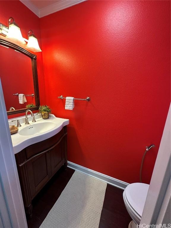 bathroom with vanity, crown molding, and toilet