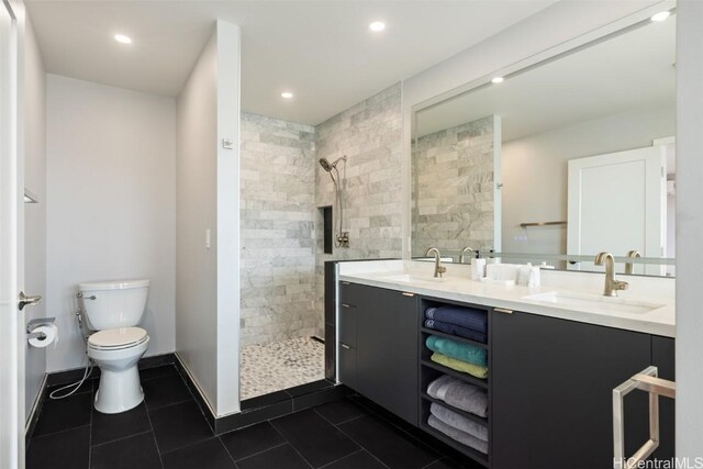 bathroom featuring tile patterned floors, vanity, toilet, and tiled shower