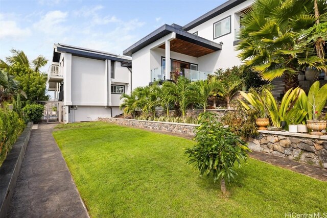 exterior space with a balcony and a front yard