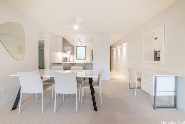 carpeted dining area with ceiling fan