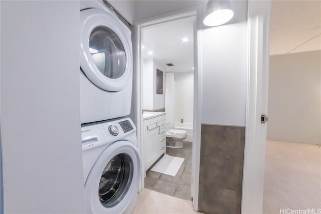 clothes washing area featuring light colored carpet and stacked washer and clothes dryer