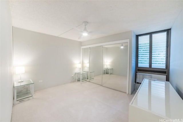 unfurnished bedroom with carpet flooring, ceiling fan, and a closet