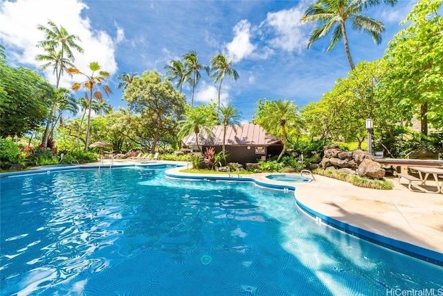 view of pool with a patio and a hot tub