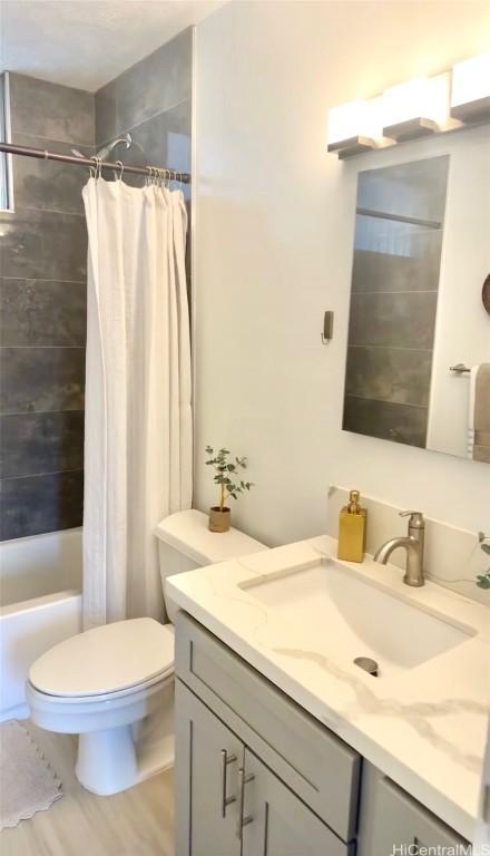 full bathroom featuring shower / bath combo with shower curtain, vanity, wood-type flooring, and toilet