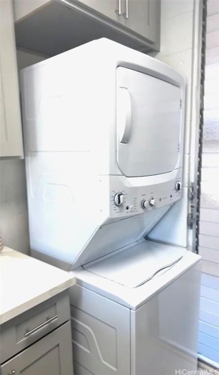 laundry area featuring stacked washer / drying machine