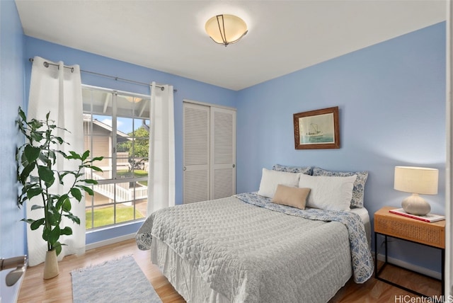 bedroom with light hardwood / wood-style floors and a closet